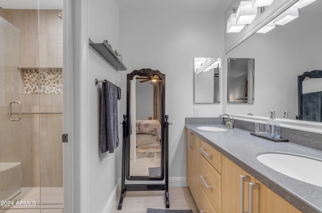 bathroom featuring tile patterned flooring, vanity, and a shower with shower door