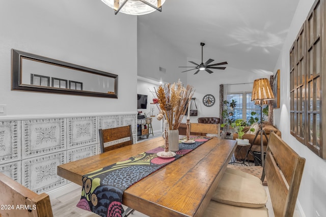 dining room with ceiling fan, high vaulted ceiling, and light wood-type flooring