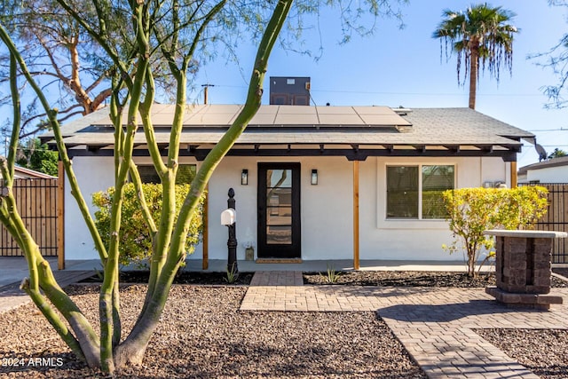 view of front of property featuring solar panels