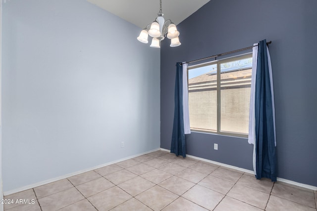 tiled spare room with lofted ceiling and an inviting chandelier