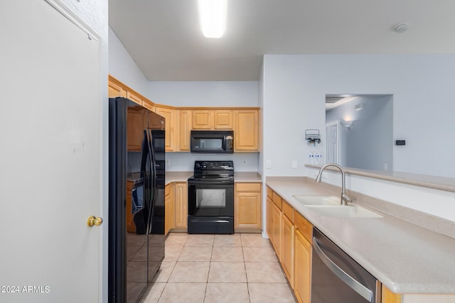 kitchen featuring kitchen peninsula, light brown cabinetry, sink, black appliances, and light tile patterned flooring