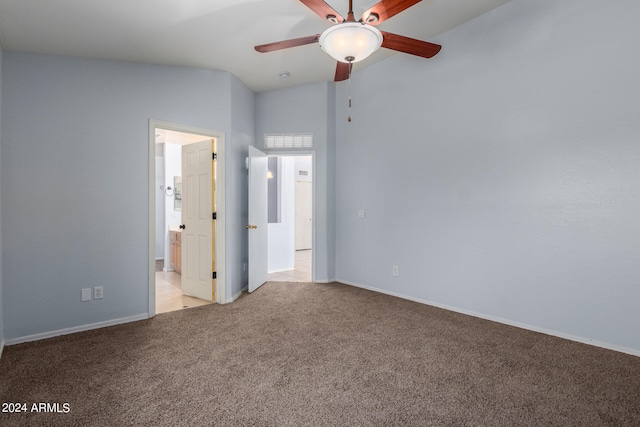 unfurnished bedroom with ceiling fan, light colored carpet, and vaulted ceiling