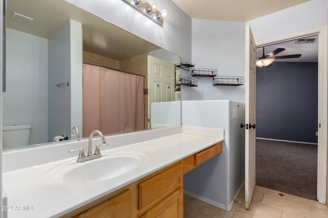 bathroom with toilet, vanity, tile patterned floors, and ceiling fan