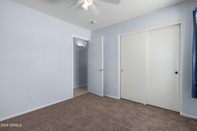 unfurnished bedroom with carpet, a closet, and ceiling fan