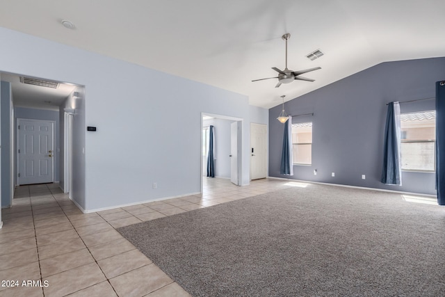 empty room with vaulted ceiling, ceiling fan, and light tile patterned flooring