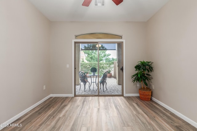 empty room with wood finished floors, ceiling fan, and baseboards