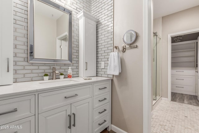 full bathroom featuring a shower stall, vanity, and baseboards