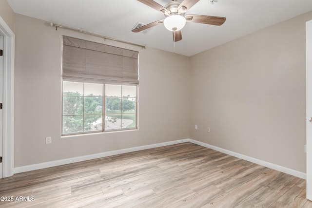 empty room featuring ceiling fan, light wood-style flooring, and baseboards