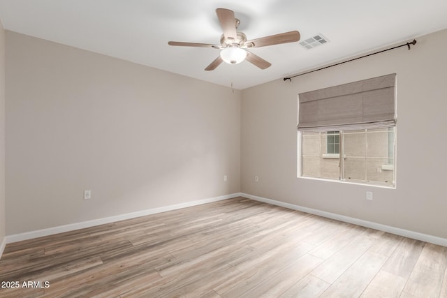 spare room with ceiling fan, wood finished floors, and baseboards