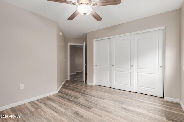 unfurnished bedroom featuring baseboards, light wood-style flooring, a closet, and a ceiling fan