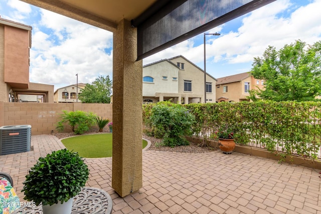 view of patio / terrace with central AC, a fenced backyard, and a residential view