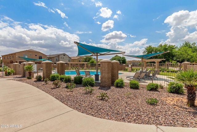 view of play area featuring fence and a community pool