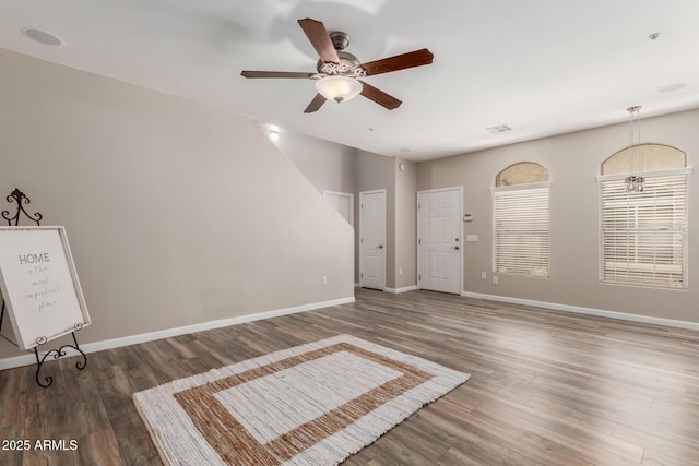 spare room featuring ceiling fan, wood finished floors, and baseboards