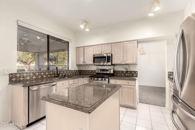 20435 N 39th Dr, Glendale, AZ 85308 - kitchen featuring light tile patterned floors, stainless steel appliances, a center island, dark stone counters, and a sink