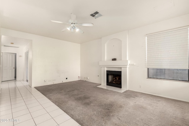 20435 N 39th Dr, Glendale, AZ 85308 - unfurnished living room with a fireplace with flush hearth, visible vents, a ceiling fan, light carpet, and light tile patterned floors