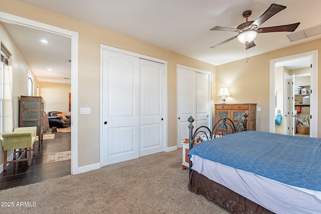 bedroom with multiple closets, dark colored carpet, and ceiling fan