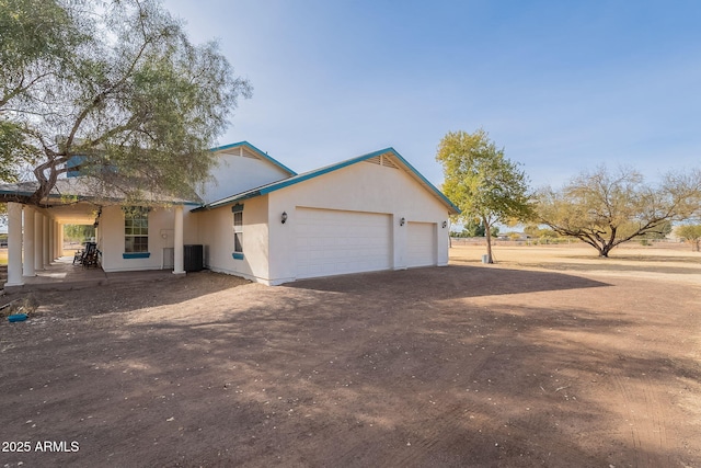 view of front of home with a garage and central air condition unit