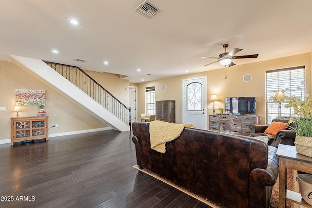 living room featuring dark hardwood / wood-style flooring, ceiling fan, and a healthy amount of sunlight