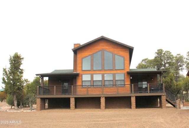 back of house featuring stairs and a chimney
