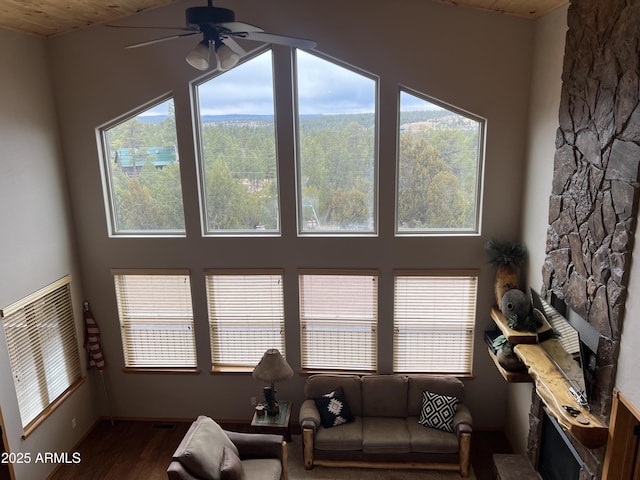 living area featuring a fireplace, plenty of natural light, a ceiling fan, and wood finished floors