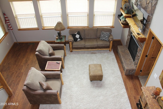 living room with wood finished floors, visible vents, a fireplace, and plenty of natural light