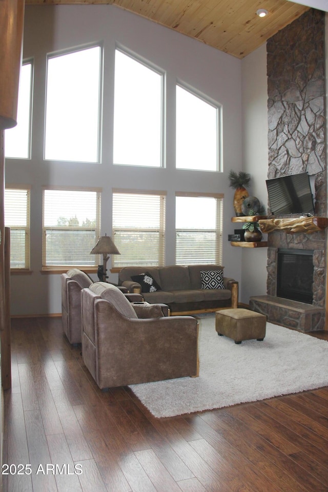 living area featuring wood-type flooring, high vaulted ceiling, a fireplace, and wood ceiling