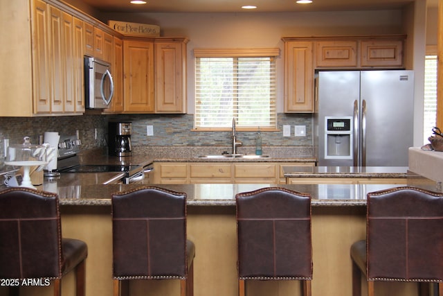 kitchen with stone countertops, tasteful backsplash, appliances with stainless steel finishes, and a sink
