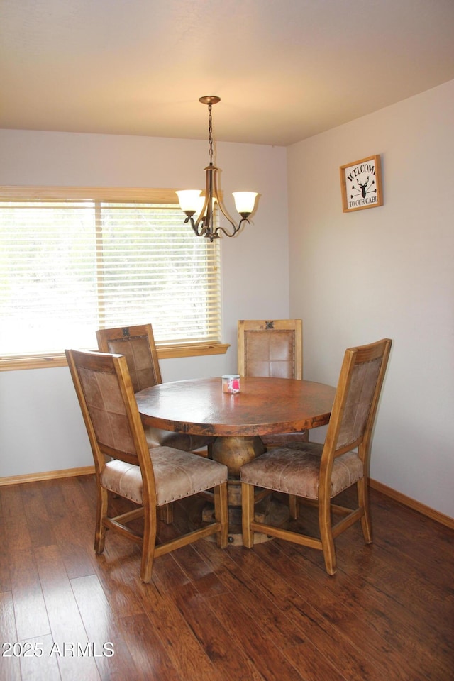 dining space with plenty of natural light, a notable chandelier, hardwood / wood-style flooring, and baseboards