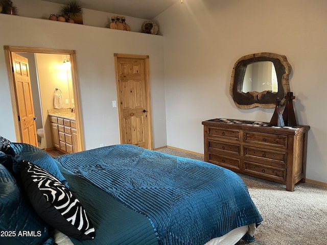 bedroom with carpet, baseboards, vaulted ceiling, and connected bathroom