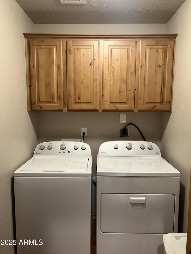 washroom featuring washing machine and dryer and cabinet space