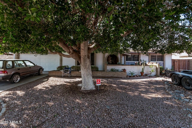 view of property hidden behind natural elements with a garage