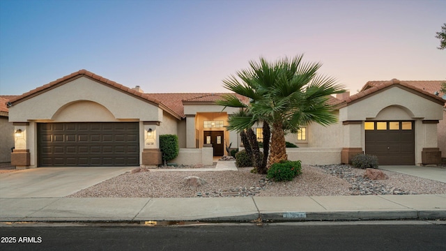 16238 N 58th St, Scottsdale, AZ 85254 - mediterranean / spanish house featuring concrete driveway, an attached garage, stucco siding, and a tiled roof