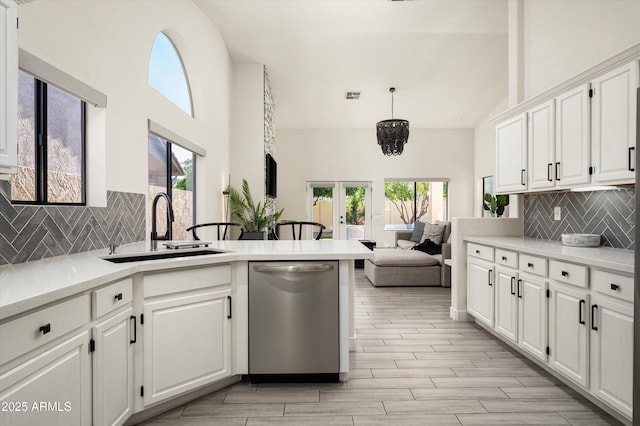 16238 N 58th St, Scottsdale, AZ 85254 - kitchen featuring stainless steel dishwasher, a high ceiling, a peninsula, backsplash, and white cabinetry