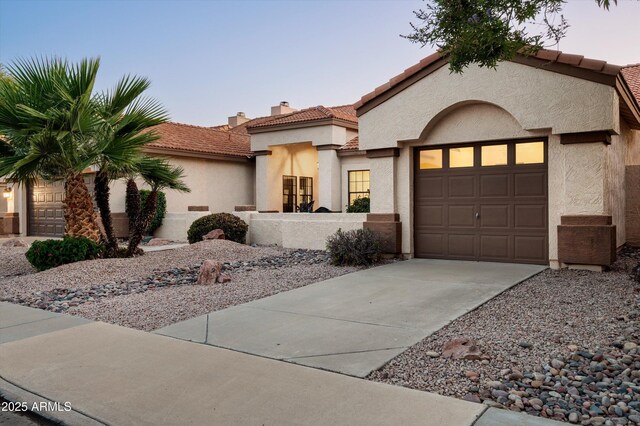 16238 N 58th St, Scottsdale, AZ 85254 - mediterranean / spanish-style house featuring concrete driveway, stucco siding, a tile roof, a chimney, and an attached garage