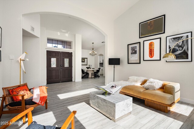 16238 N 58th St, Scottsdale, AZ 85254 - living room featuring arched walkways, light wood-style floors, a chandelier, and high vaulted ceiling