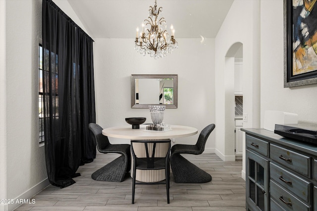 16238 N 58th St, Scottsdale, AZ 85254 - dining room with arched walkways, a chandelier, vaulted ceiling, and light wood-style flooring