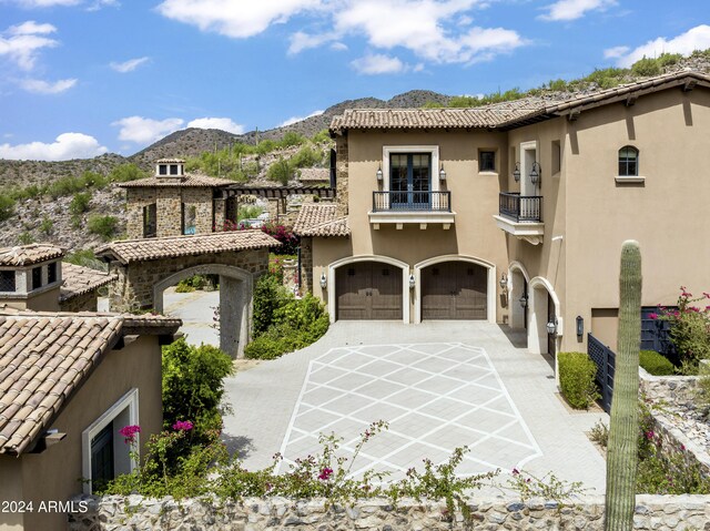 view of front of home with a balcony, a mountain view, and a garage