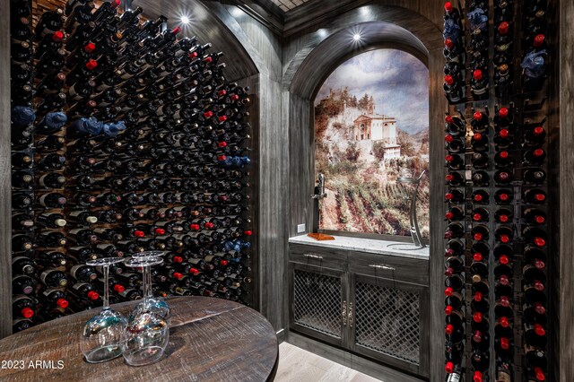 wine room with light wood-type flooring and crown molding