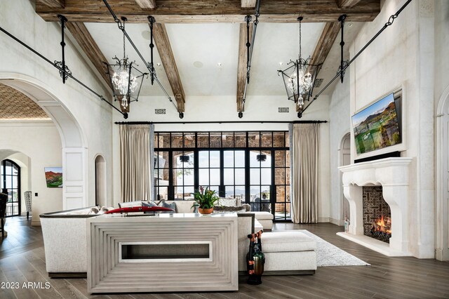 kitchen with beamed ceiling, a notable chandelier, dark wood-type flooring, and a high ceiling