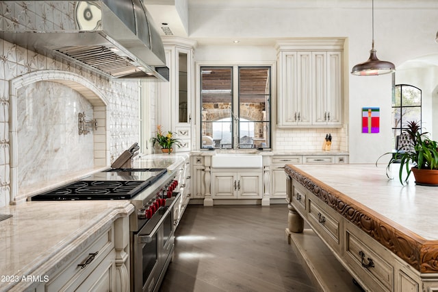 kitchen featuring light stone counters, backsplash, high end stainless steel range, and a wealth of natural light