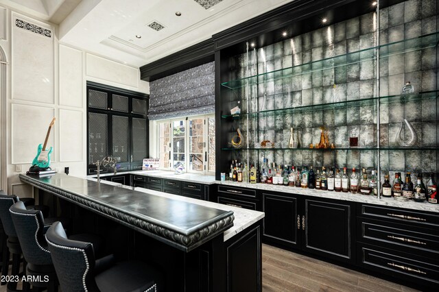 bar featuring light wood-type flooring and ornamental molding