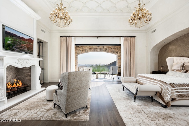 bedroom featuring an inviting chandelier, access to exterior, hardwood / wood-style flooring, and ornamental molding