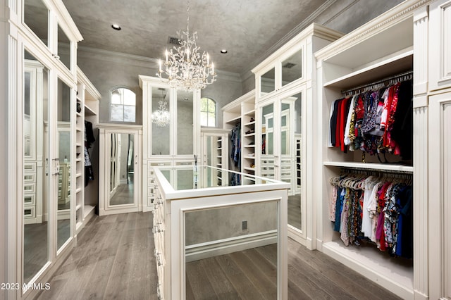 walk in closet featuring wood-type flooring, a notable chandelier, and french doors