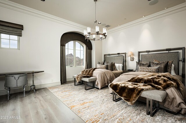 bedroom featuring an inviting chandelier, crown molding, and hardwood / wood-style floors