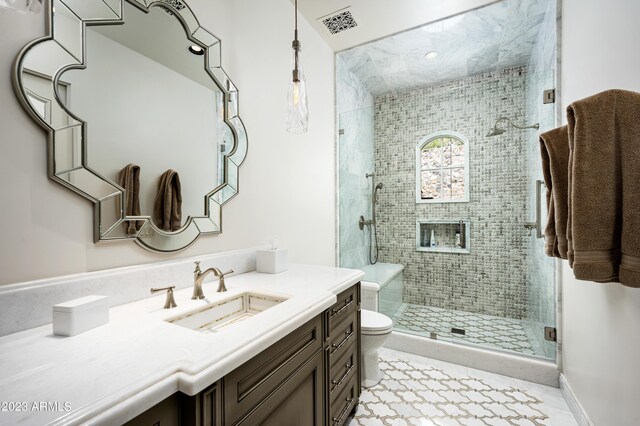 bathroom featuring vanity, toilet, and a shower with door