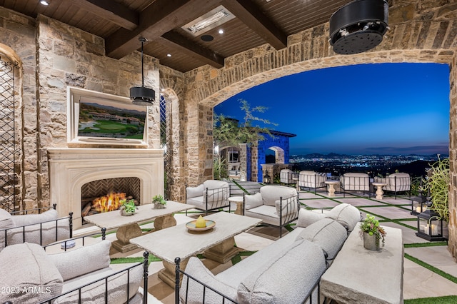 patio terrace at dusk with an outdoor living space with a fireplace