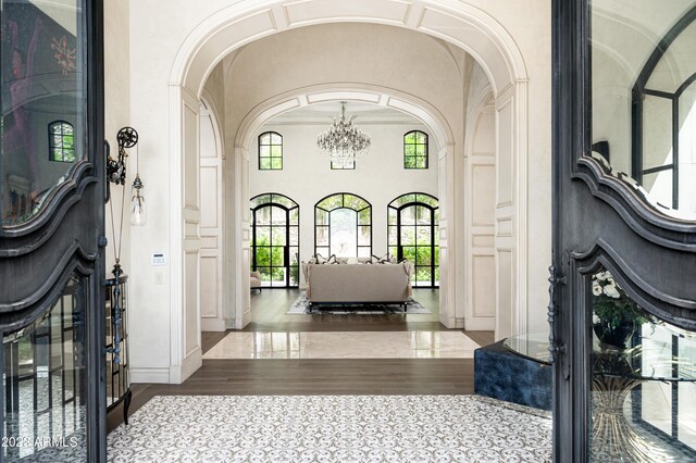 foyer entrance featuring wood-type flooring and a notable chandelier