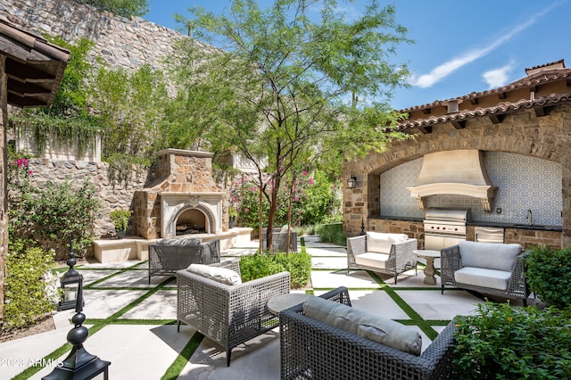 view of patio / terrace with area for grilling, an outdoor living space with a fireplace, and sink