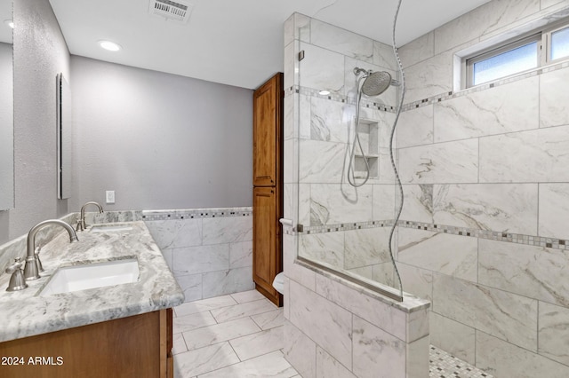 bathroom with vanity and a tile shower