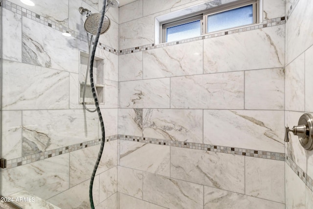 interior details featuring tiled shower